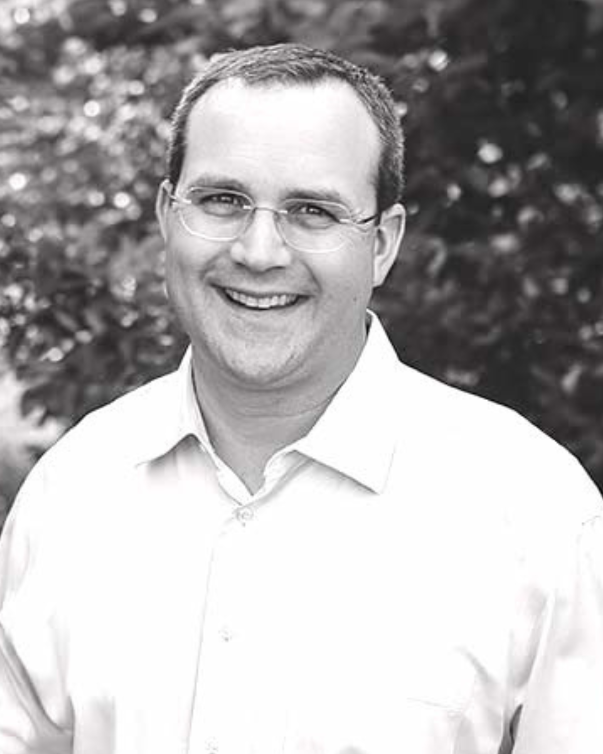 Dr. Jarrod Jones pictured in black in white with a white shirt